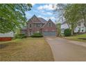 Beautiful two-story brick home with a manicured lawn and a spacious two-car garage at 5355 Avonshire Ln, Cumming, GA 30040