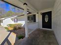Inviting front porch with white railings and a decorative black front door at 621 Hood Rd, Stockbridge, GA 30281