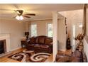 Inviting living room featuring a decorative fireplace, hardwood floors, and a comfortable leather sofa at 30 Woodbrook Ct, Mcdonough, GA 30252