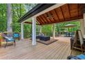 The covered deck with a wood ceiling has lots of room for entertaining and enjoying the outdoors at 950 Ivy St, Cumming, GA 30041