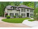 A traditional two-story brick house has a green lawn, mature landscaping, and a circular driveway at 950 Ivy St, Cumming, GA 30041