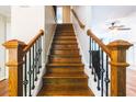 Beautiful staircase with wood steps, decorative iron railings, and detailed wood posts at 3107 Sandhurst Dr, Woodstock, GA 30189