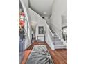 Bright foyer featuring hardwood floors, a soaring ceiling, and a staircase with white railings at 3822 Harris Nw Blvd, Kennesaw, GA 30144