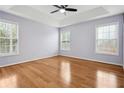 Bright main bedroom features a ceiling fan, trey ceiling, and multiple windows letting in plenty of light at 810 Abbotts Mill Ct # 83, Duluth, GA 30097