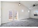Bright, carpeted living room with vaulted ceilings and double doors leading to the backyard at 1025 Lakeside Circle, Covington, GA 30016