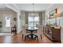 Formal dining room boasts hardwood floors, natural light, and stylish chandelier at 15 Azalea Lakes Ct, Dallas, GA 30157