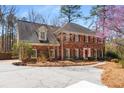 Charming brick home featuring well-maintained landscaping and a spacious driveway at 9835 Trace Vly, Sandy Springs, GA 30350