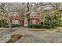 Charming red brick townhome featuring a well-manicured lawn and flowering trees at 2892 Norfair Ne Loop, Lithonia, GA 30038