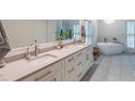 Bright bathroom featuring a double sink vanity, soaking tub, and large format tile flooring at 363 Wilcrest Dr, Lawrenceville, GA 30044