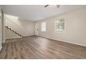 Bright living room with wood-look floors, large windows, and a staircase at 6354 Shannon Pkwy # 15D, Union City, GA 30291