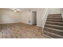 Inviting living room with staircase features wood-look floors and neutral paint at 6354 Shannon Pkwy # 15D, Union City, GA 30291