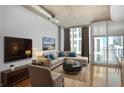 Inviting living room with a comfortable sectional sofa, floor-to-ceiling windows, and modern décor at 943 Peachtree Ne St # 1003, Atlanta, GA 30309