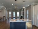 Bright kitchen island with open living room, fireplace, and modern lighting at 122 Stonehouse Dr, Cumming, GA 30040