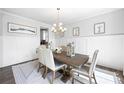 Elegant dining room featuring wainscoting, a modern chandelier, and a stylish area rug at 2121 Hempstead Ct, Snellville, GA 30078