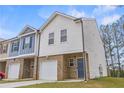 Two-story townhome boasts brick accents, single car garage, and neutral color palette at 7005 Livia Pt, Riverdale, GA 30296