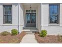 Close-up of the home's front entrance with dark doors and stone steps framed by brick at 123 Candler Loop, Acworth, GA 30101
