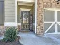 Inviting entryway with decorative front door and stone accents, showcasing curb appeal at 142 Richmond Way, Villa Rica, GA 30180