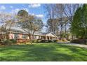 Beautifully landscaped front yard of a brick home with mature trees at 1566 Arden Sw Dr, Marietta, GA 30008