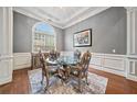 Formal dining room with tray ceiling, wainscoting, large windows, and seating for four at 2121 Whitekirk Nw St, Kennesaw, GA 30152