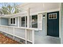 Welcoming entrance with white railing, a dark teal front door, white shutters, and painted brick at 3069 Thrasher Cir, Decatur, GA 30032