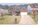 Lovely two-story brick home featuring a manicured lawn and a two-car garage at 4349 Sublime Trl, Atlanta, GA 30349