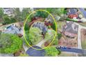 An aerial view showing the backyard and surrounding property, mature trees, and circular driveway at 803 Amerden Ponds Ct, Johns Creek, GA 30097