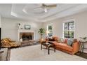 Cozy living room with a brick fireplace, tray ceilings, and plush seating, creating a warm and inviting atmosphere at 263 Keller Dr, Mcdonough, GA 30252
