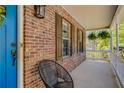 Inviting covered porch with brick accent wall, decorative shutters, and a cozy seating area perfect for relaxation at 263 Keller Dr, Mcdonough, GA 30252