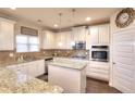 Modern kitchen with white cabinetry, granite countertops, and stainless steel appliances at 910 Shannon Mist Dr, Loganville, GA 30052