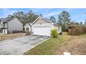 Side view of house featuring an attached two car garage, lawn, and a fenced-in yard at 217 Depot Ln, Dallas, GA 30157