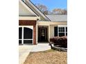 Home's exterior displays brick accents, a black front door, and manicured landscaping at 779 Harvest Brook Dr, Lawrenceville, GA 30043