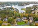 Stunning aerial view of a beautiful home nestled among trees with lake and golf course views at 1100 Muirfield Ct, Alpharetta, GA 30005