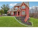 Well-maintained brick home with lush lawn and landscaping, showcasing a side view of the property at 2220 Stirling Bridge Rd, Cumming, GA 30041
