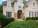 Inviting front entrance with double doors, stone detailing, manicured bushes, and a 'Welcome' sign at 507 Autumn Walk, Canton, GA 30114