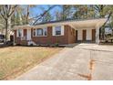 Picture of a cozy brick home featuring a carport, a walkway, and a well-maintained lawn at 1207 Ellington Dr, Morrow, GA 30260