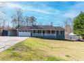 Charming single story home featuring an attached garage, a front porch, and a paved driveway at 11555 Brown Bridge Rd, Covington, GA 30016