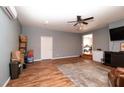 Open living area features wood floors, a modern ceiling fan, a tv and multiple entry and access points at 11555 Brown Bridge Rd, Covington, GA 30016
