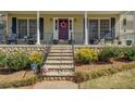 Charming front entrance with stone steps, wrought iron railing, manicured landscaping, and a colorful wreath at 802 Sugar Creek Se Dr, Conyers, GA 30094
