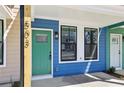 A blue townhome featuring a green front door, black-trimmed windows, and light-colored porch flooring at 1095 Tucker Ave # 503, Atlanta, GA 30310