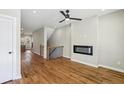 Living room featuring hardwood floors, a black ceiling fan, a fireplace, and views to other rooms at 1095 Tucker Ave # 503, Atlanta, GA 30310