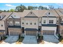 A modern townhome exterior features brick and siding, with a two-car garage and well-maintained landscaping at 2120 Sonoma Se Dr, Smyrna, GA 30080