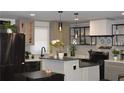 Stylish kitchen with stainless steel refrigerator, an island, and sleek black pendant lighting at 1031 Camilla Sw St, Atlanta, GA 30314