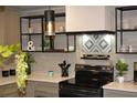 Modern kitchen featuring sleek black appliances, custom tile backsplash, and open shelving at 1031 Camilla Sw St, Atlanta, GA 30314