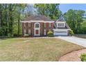 Beautiful two-story brick home with an attached garage and established landscaping at 3590 Lester Sw Ct, Lilburn, GA 30047
