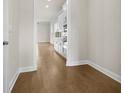 Hallway featuring beautiful hardwood floors, neutral walls, and access to other rooms, including the kitchen at 636 Silva St, Cumming, GA 30040