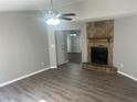 Inviting living room featuring a stone fireplace, ceiling fan, and stylish flooring, perfect for relaxation at 2039 Corners Cir, Lithonia, GA 30058