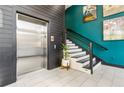 Hallway featuring elevator, staircase and accent wall with modern art at 22 Airline Ne St # 204, Atlanta, GA 30312