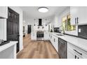 Well-lit kitchen boasts stainless steel appliances, white cabinets, and dark marble countertops for a modern aesthetic at 2615 Holly Ln, Marietta, GA 30062