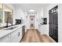 Bright kitchen featuring white cabinets and countertops accented by modern black fixtures and backsplash at 2615 Holly Ln, Marietta, GA 30062