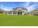 Large backyard with a covered patio, well-maintained lawn, and privacy fence at 4720 Gablestone Xing, Hoschton, GA 30548